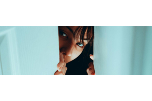 vrouw-spiekt-achter-blauwe-gordijnen