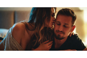 vrouw fluistert in oor van man op bed