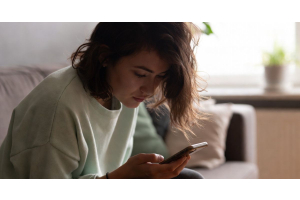 vrouw-kijkt-teleurgesteld-op-telefoon