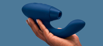 blauwe womanizer duo in hand op blauwe achtergrond