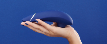 blauwe womanizer premium in hand op blauwe achtergrond