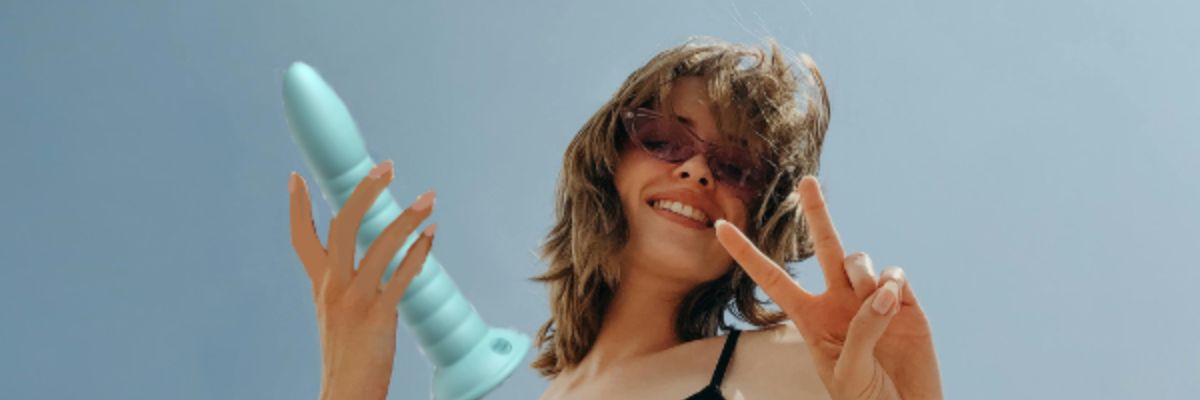 vrolijke-vrouw-houdt-blauwe-dildo-vast